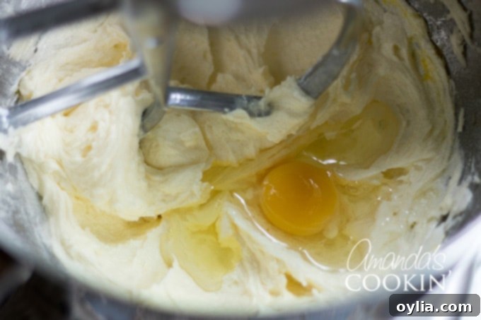 Velvet Tiramisu Dream 4 Eggs being added to the cake batter in a stand mixer.