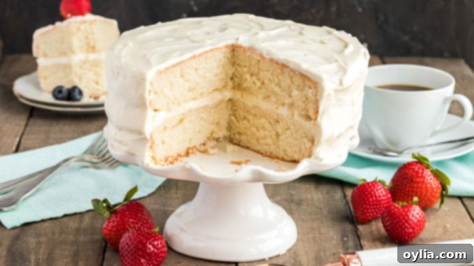 Only 8 ingredients needed for this fluffy white cake recipe that bakes up in just 30 minutes! Perfect for a party, in layers, or baked as a sheet cake! white cake with two slices removed sitting on a cake plate