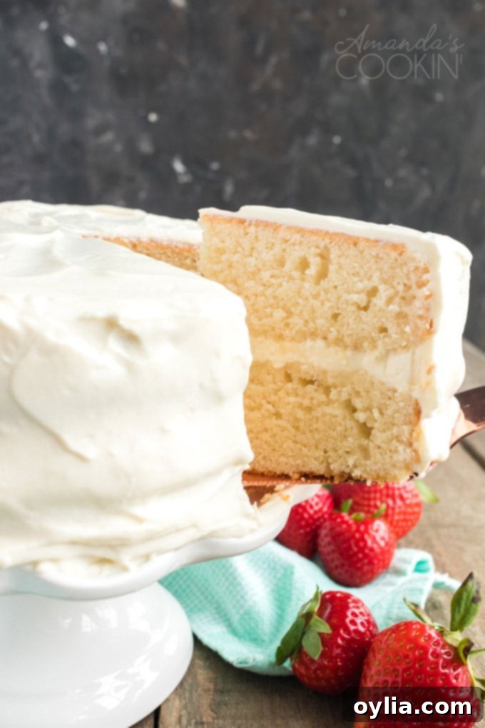 Only 8 ingredients needed for this fluffy white cake recipe that bakes up in just 30 minutes! Perfect for a party, in layers, or baked as a sheet cake! removing a slice of white cake from platter