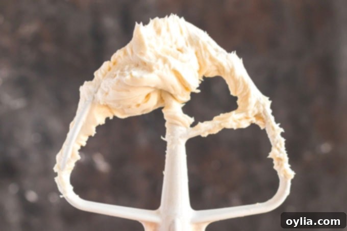 Timeless Vanilla Cake 6 stand mixer paddle attachment covered in cream cheese mixture