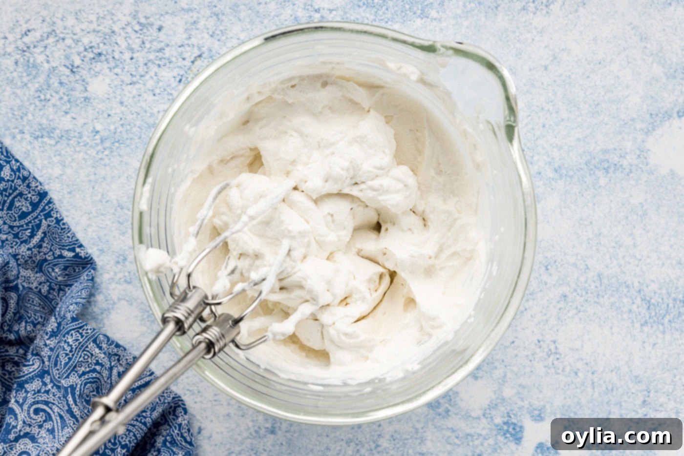 Whipped cream in a bowl with mixer attachments