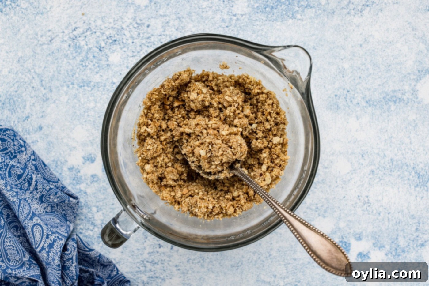 almond and graham cracker mixture in a food processor with a spoon