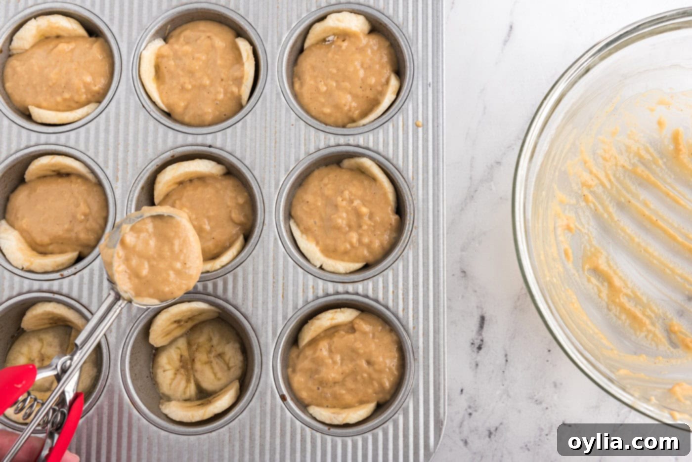 adding muffin ingredients to banana lined muffin pan