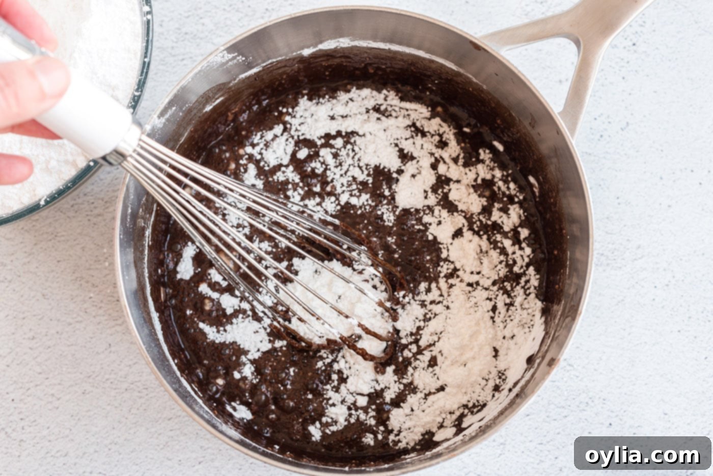 Whisking the ingredients for the chocolate fudge frosting in a saucepan