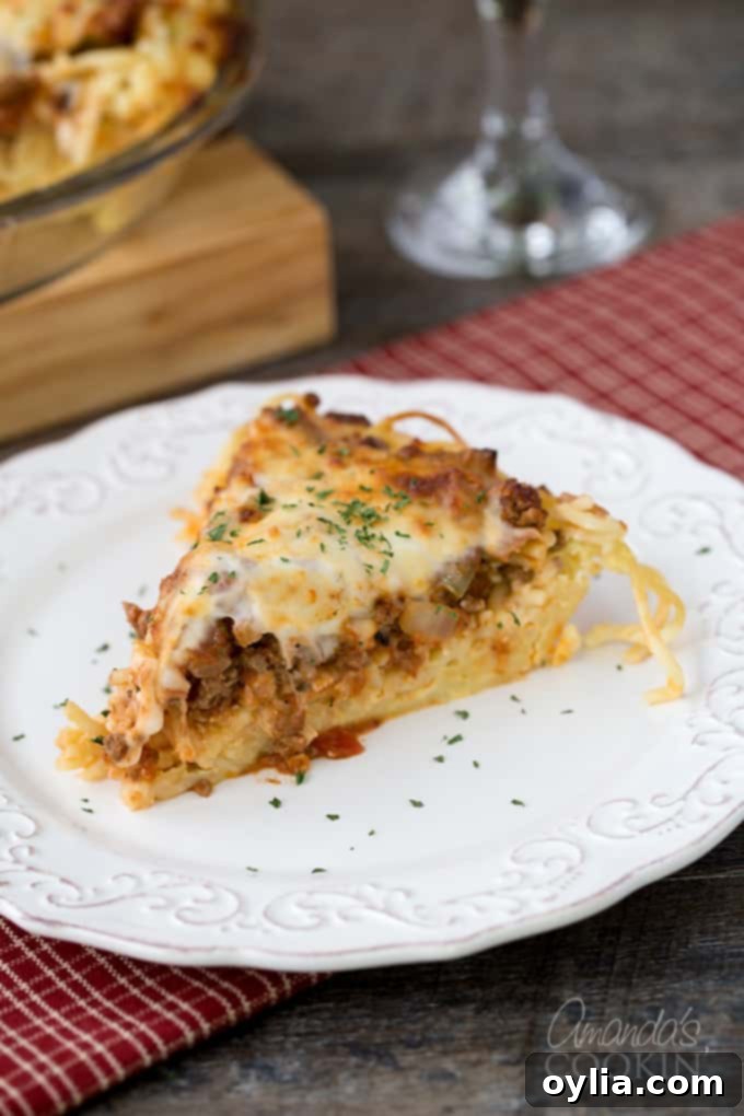 A slice of spaghetti pie on a white plate.