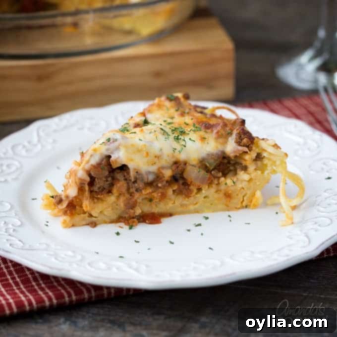 A slice of spaghetti pie on a white plate.