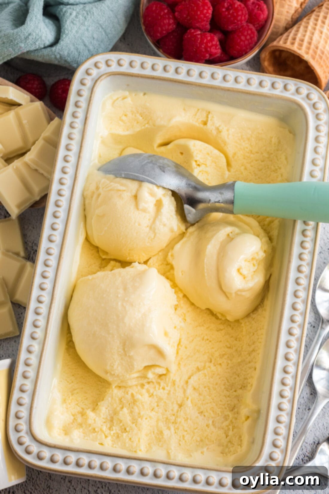 Scoops of White Chocolate Ice Cream in a pan with an ice cream scoop