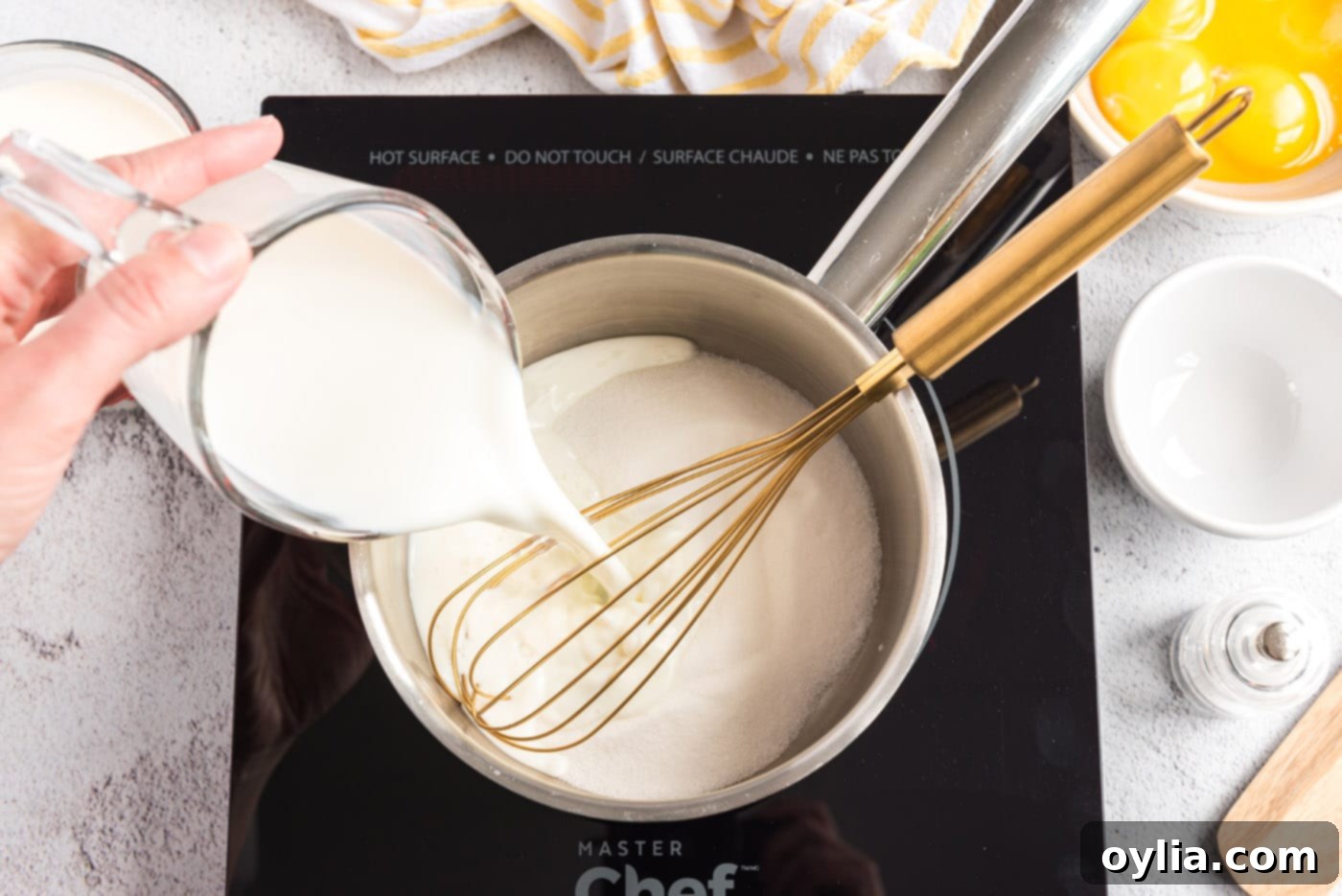 A photo of milk being poured into a saucepan of sugar and salt