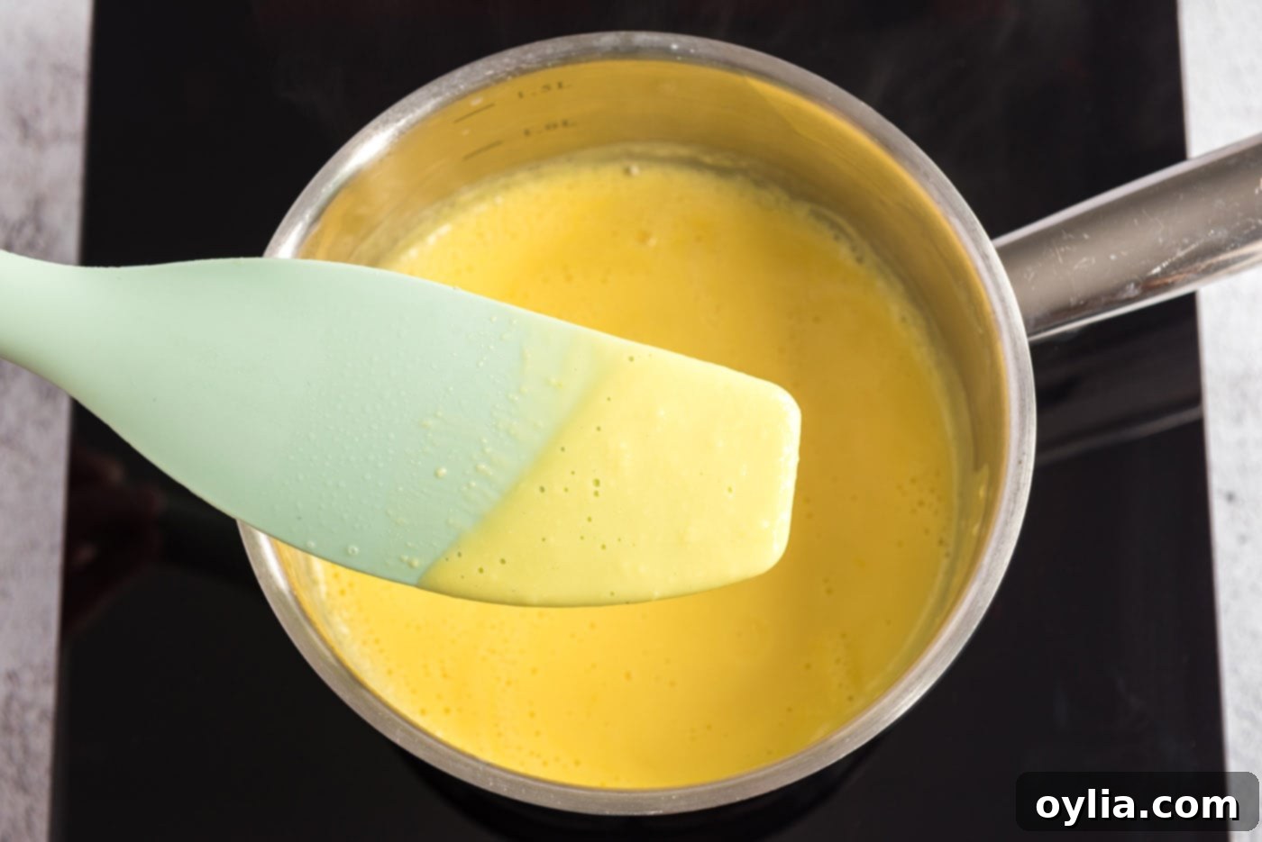 Egg yolk mixture on a spatula showing thickness