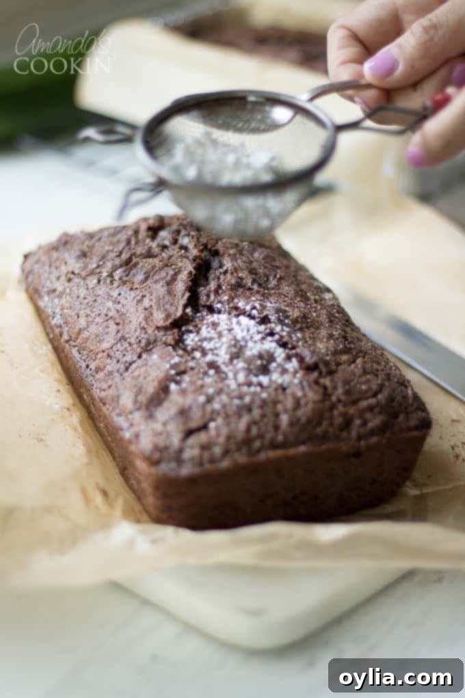 Adding powdered sugar to a loaf of chocolate zucchini bread