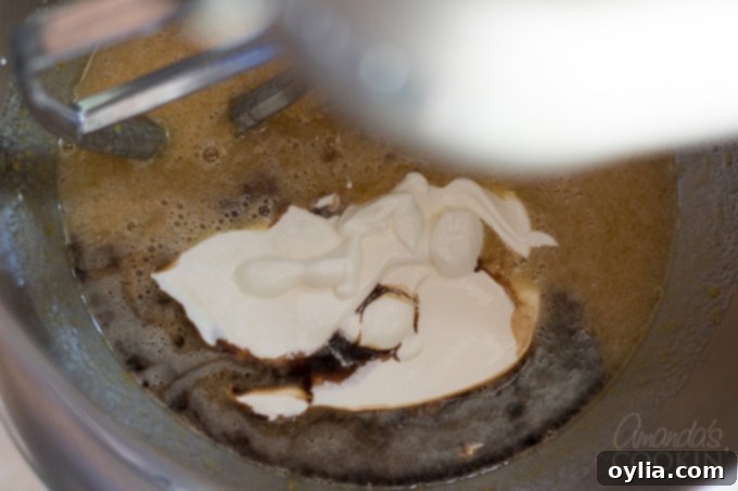 Sour cream and vanilla added to the mixer bowl with other wet ingredients