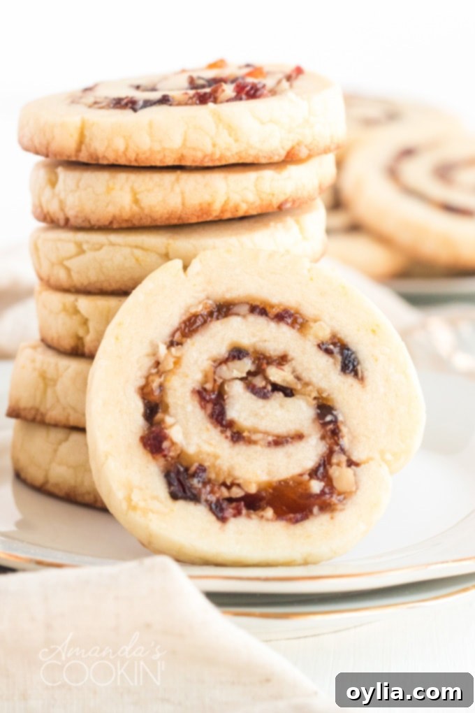 A stack of perfectly baked cranberry orange spiral cookies, highlighting their beautiful and consistent swirl patterns.