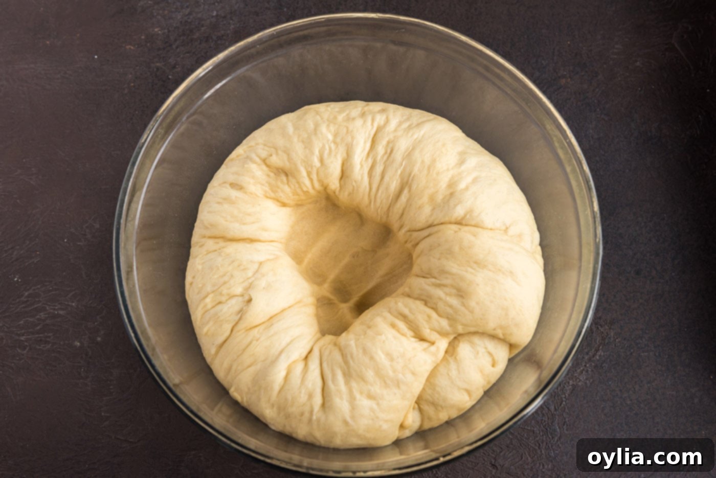 punching a hole into yeast dough in a bowl