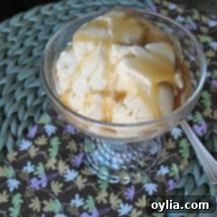 A close up picture of brown sugar vanilla bean ice cream in a clear bowl with caramel drizzle on top.