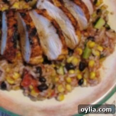 An overhead photo of a plate of spicy grilled chicken with baja black beans and rice.