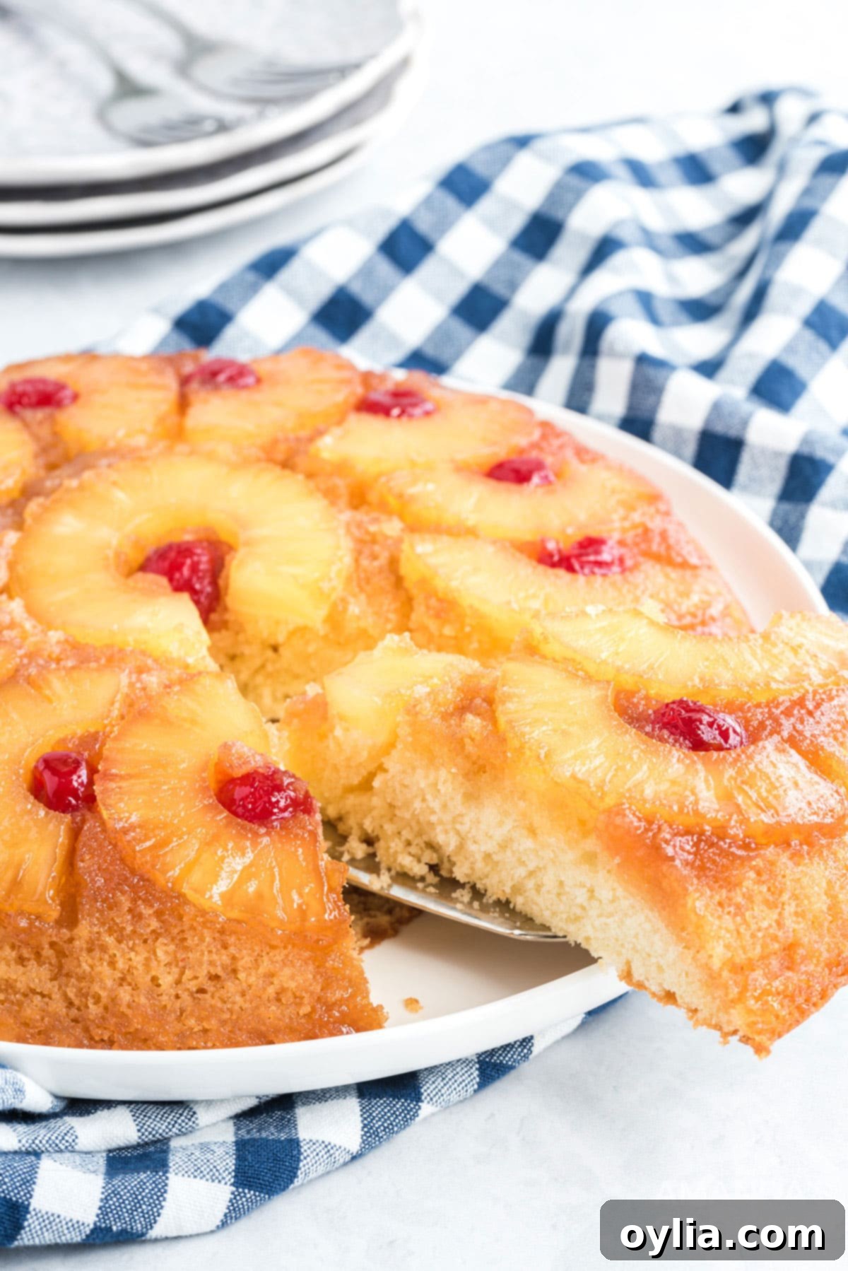 Removing a perfect slice of pineapple upside down cake from the skillet with a spatula.