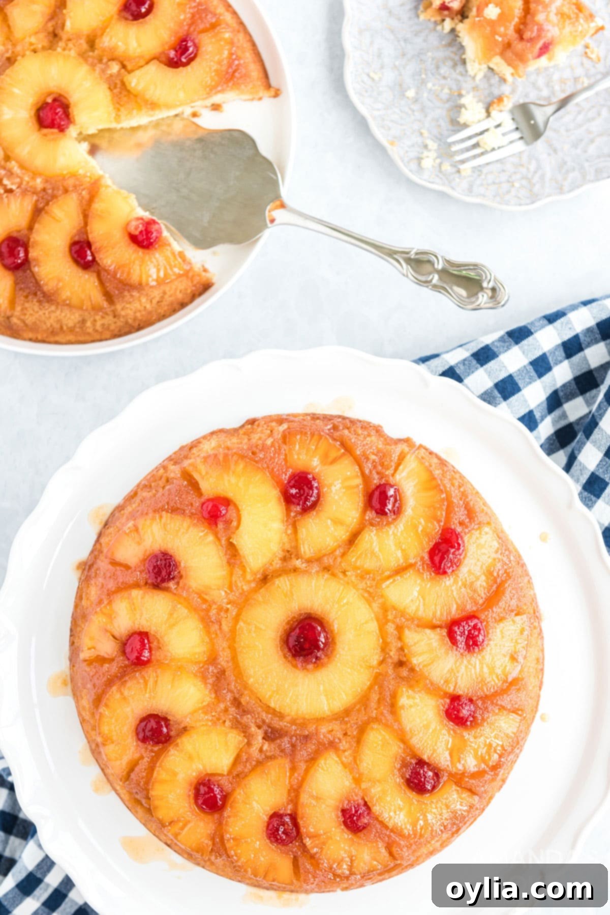 Overhead view of two golden, perfectly baked pineapple upside down cakes in cast iron skillets.
