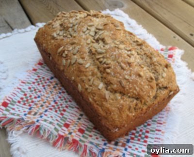 The sunflower whole wheat quick bread in its loaf pan, showing the golden-brown crust and scattered seeds.