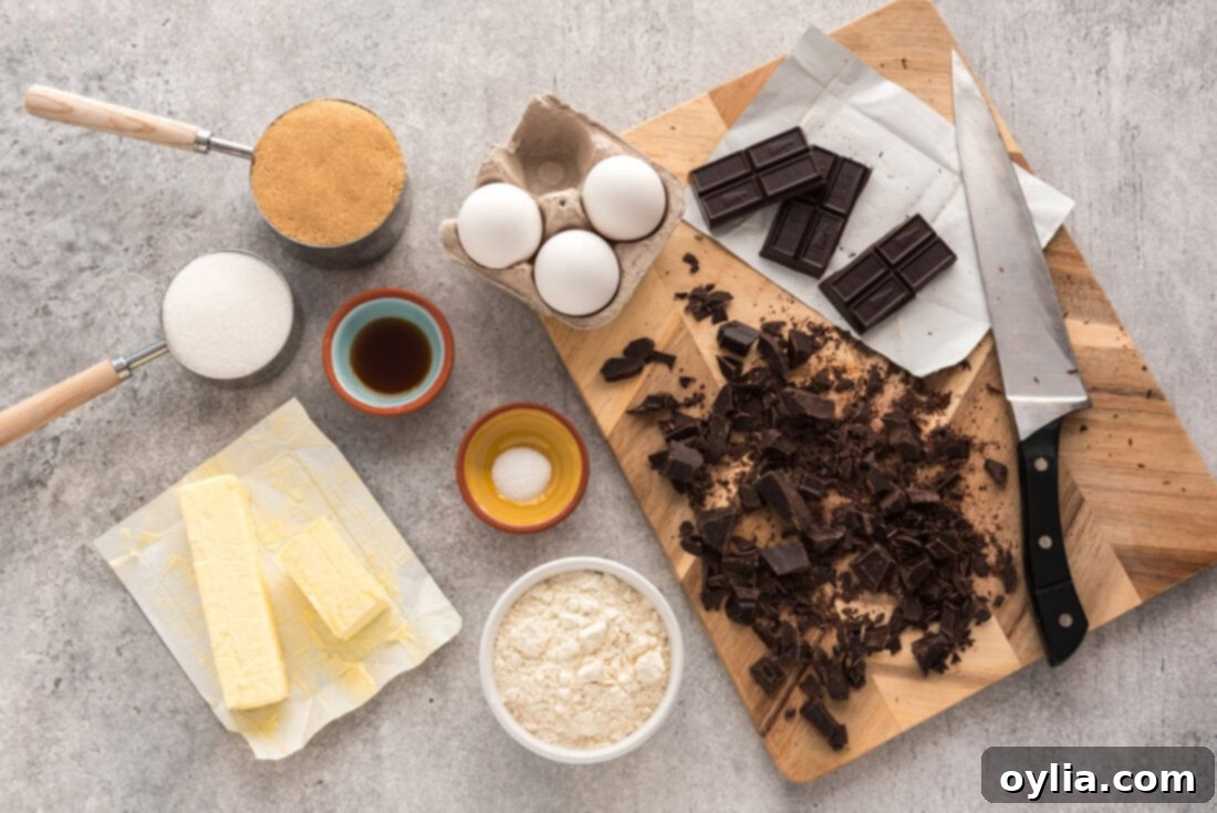 A flat lay of all the fresh, high-quality ingredients neatly arranged for making Cast Iron Skillet Brownies, including butter, unsweetened chocolate, sugars, eggs, vanilla, flour, and salt.