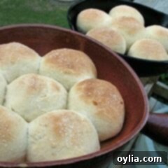 A close up photo of homemade dinner rolls in two cast iron skillets.