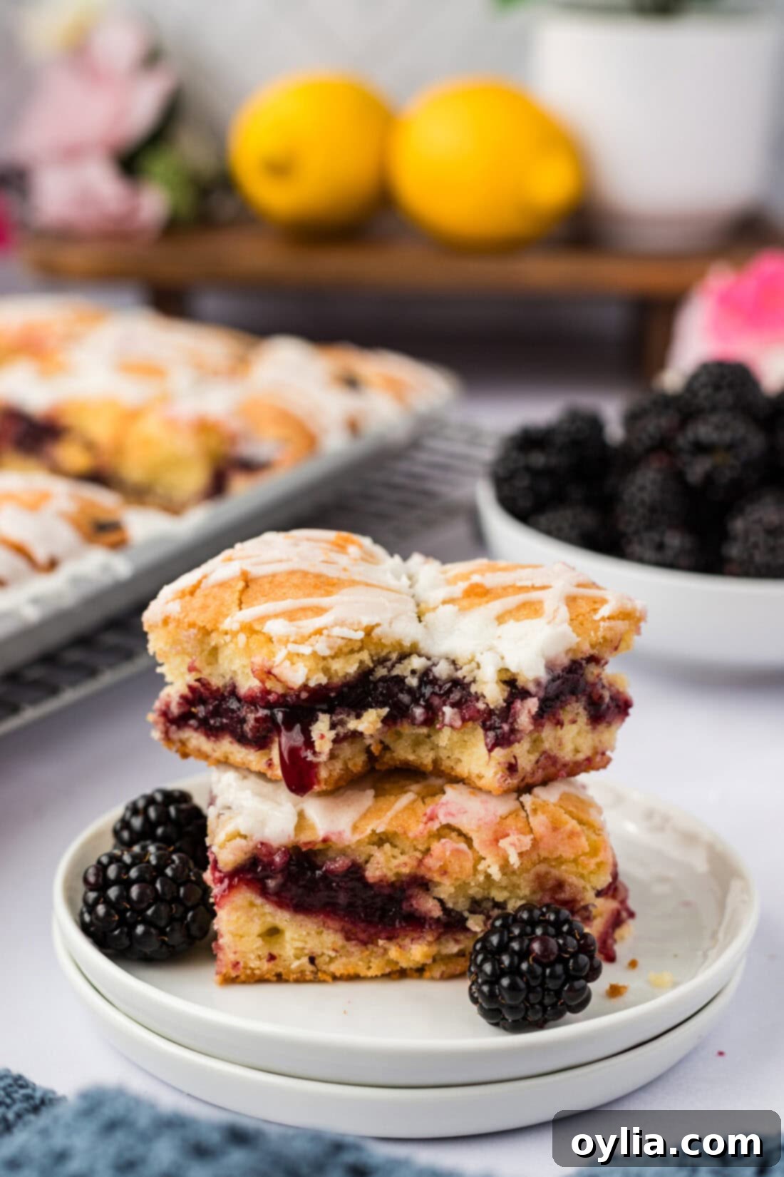 Stack of two Blackberry Pie Squares on a plate, showcasing the layers and glaze