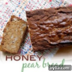 An overhead photo of a loaf of honey pear bread with a slice on the side.