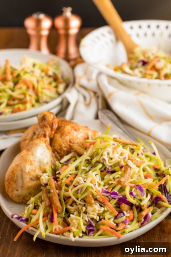 A beautifully plated dish featuring crispy fried chicken served alongside a generous portion of fresh Asian Broccoli Slaw.