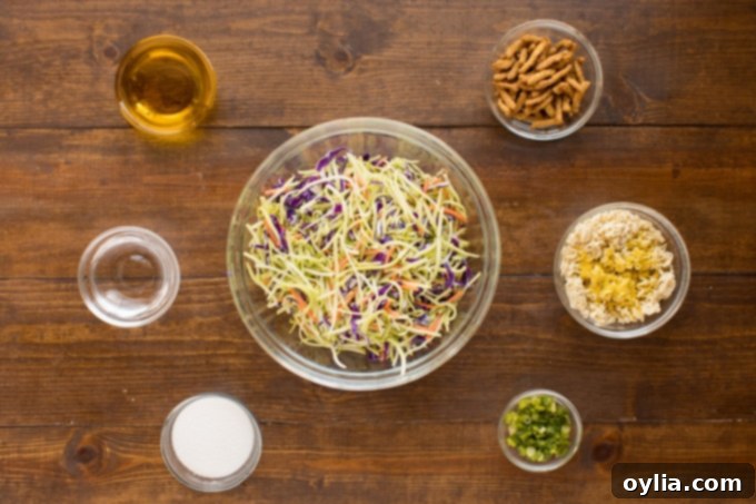 An organized display of fresh ingredients for homemade Asian Broccoli Slaw laid out on a clean cutting board, ready for preparation.