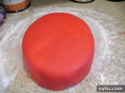 A photo of a a cake covered in red fondant.
