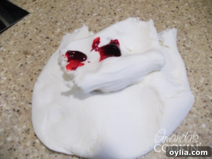 A photo of white fondant with red food coloring on top.