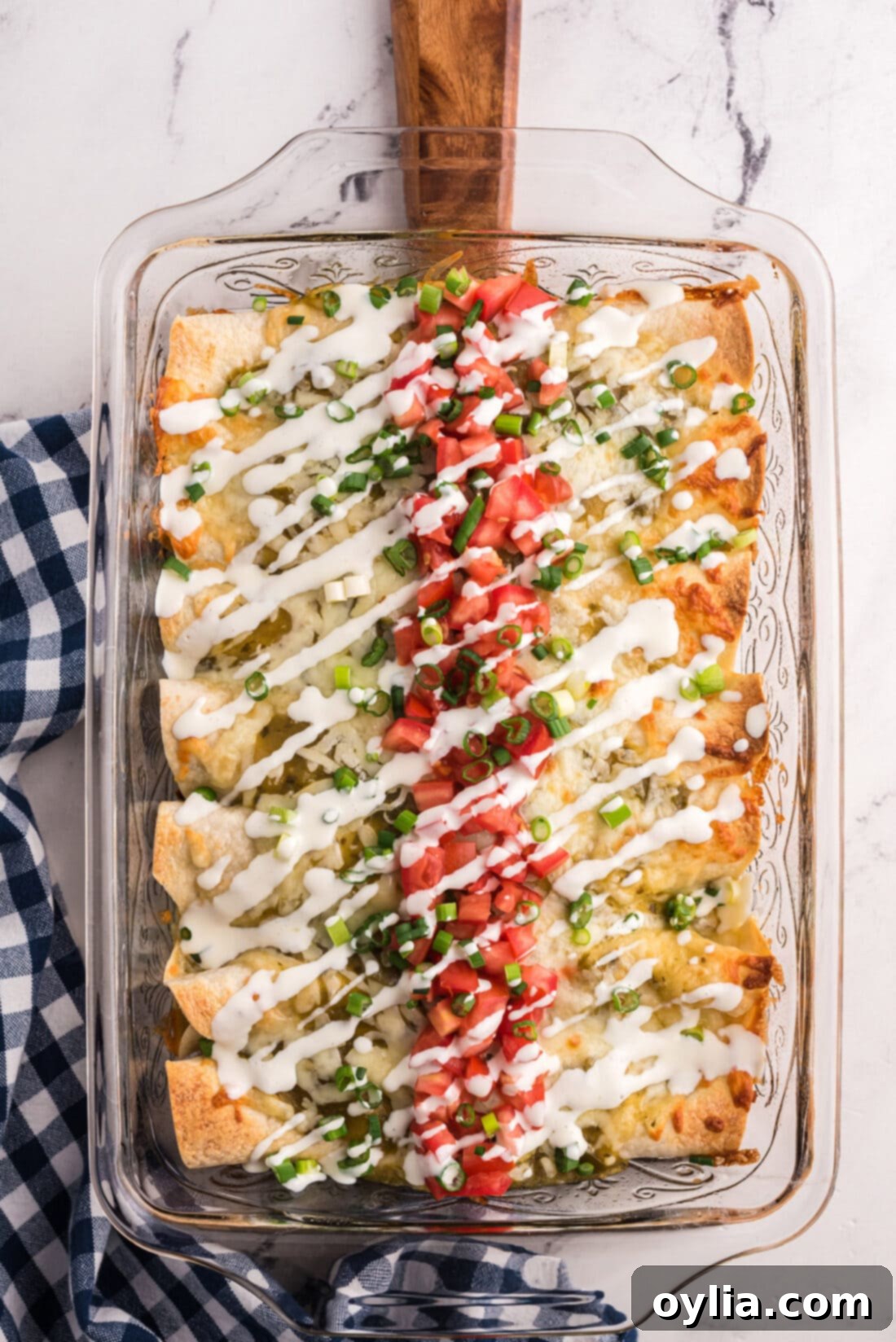 Overhead view of a baking pan filled with golden-brown Shredded Beef Enchiladas, topped with melted cheese and ready to serve.