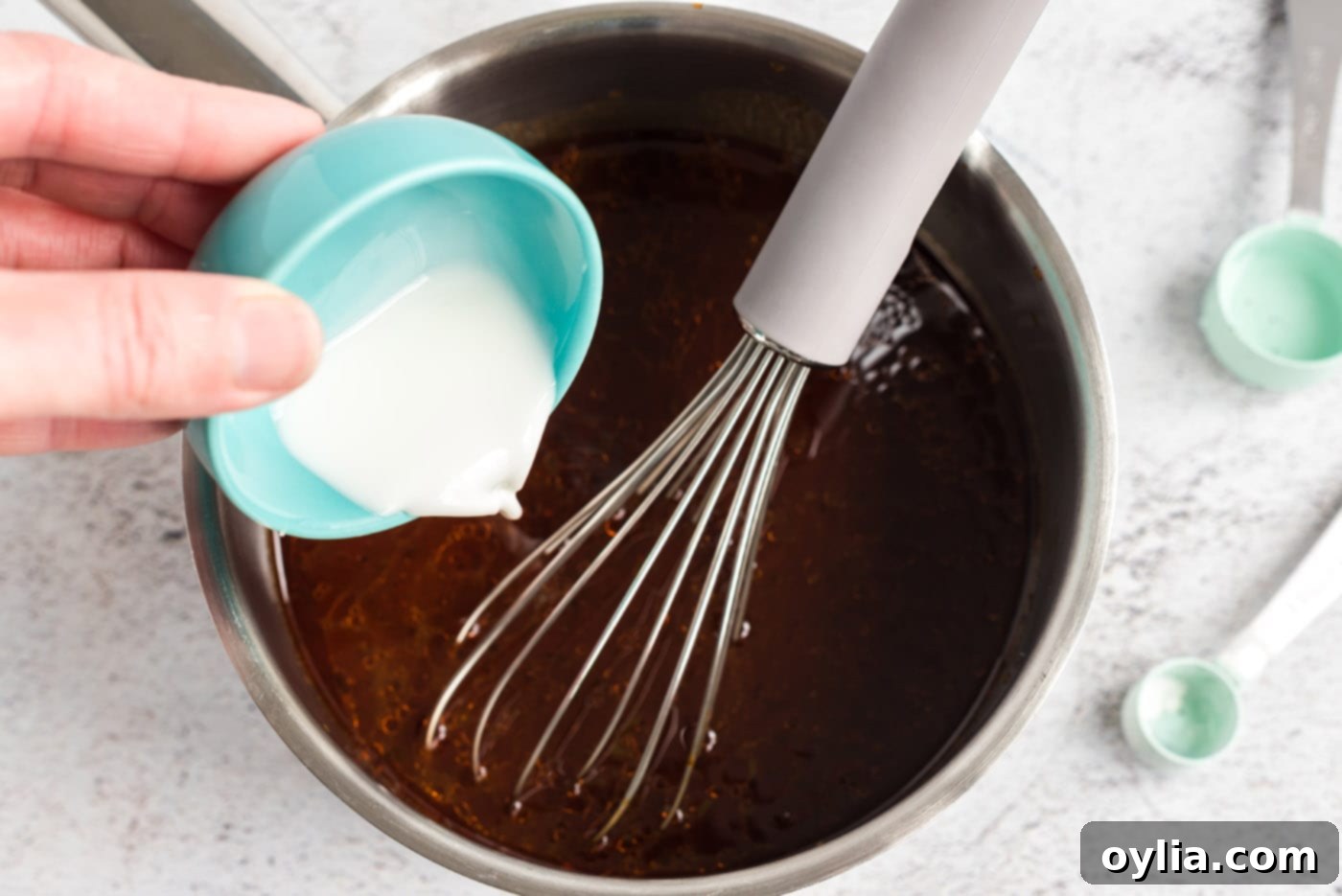 Easy Slow Cooker Pulled Pork 11 Adding cornstarch mixture to barbecue sauce in a saucepan