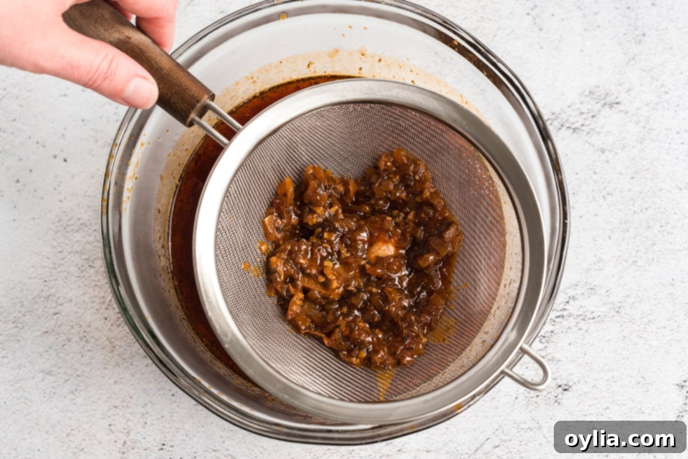 Easy Slow Cooker Pulled Pork 9 Straining the rich pulled pork sauce