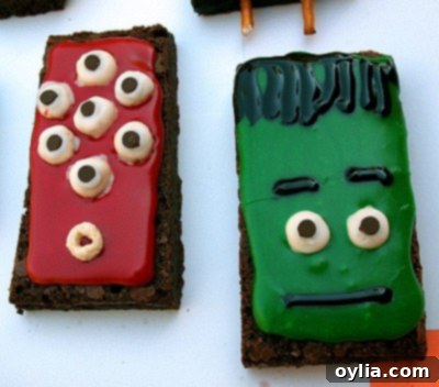 Close-up of a Frankenstein-themed monster brownie with green icing and pretzel bolts