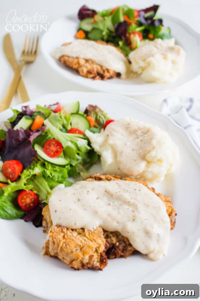 chicken fried steak with salad and potatoes on a plate