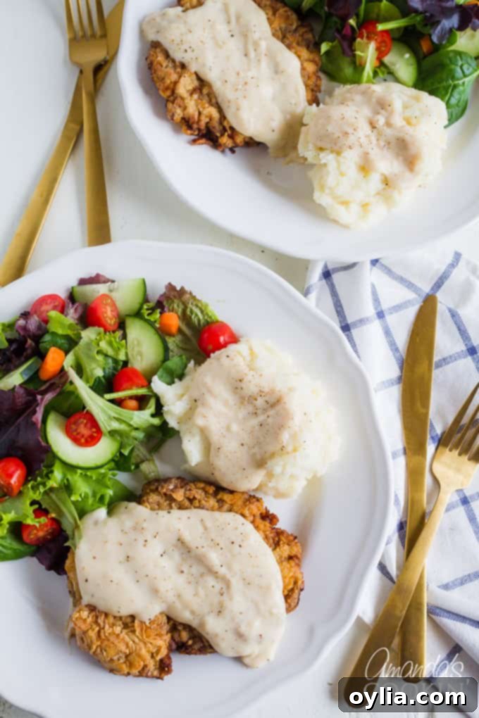 Chicken Fried Steak with potatoes and side salad on plate