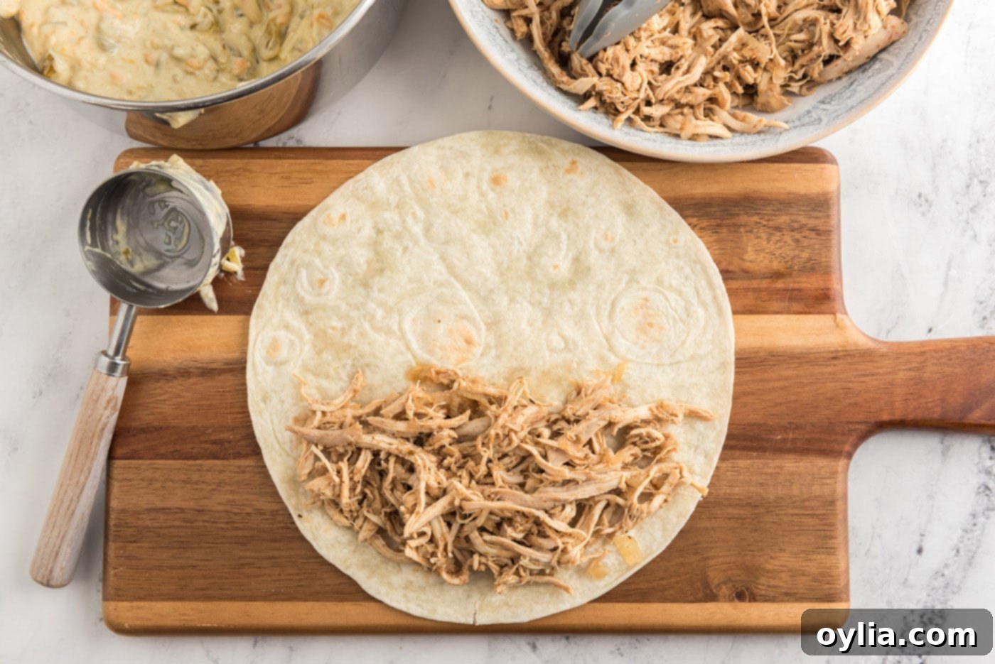 Shredded chicken mixture placed on a flour tortilla