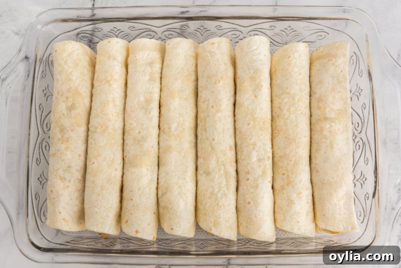 Rolled enchiladas arranged neatly in a baking dish