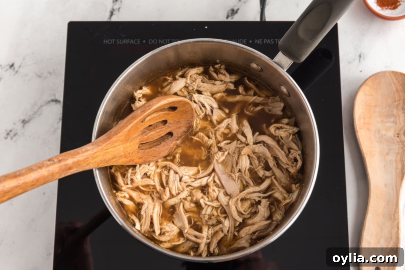 Shredded chicken added to pot with chicken broth mixture