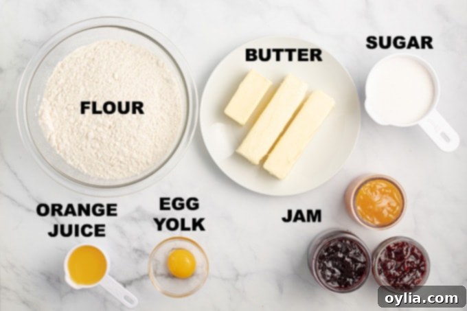 Essential ingredients for thumbprint cookies laid out: flour, butter, sugar, orange juice, and egg yolk, ready for mixing.