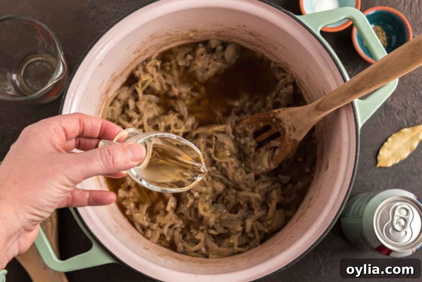 pouring white wine vinegar into pot with onion mixture