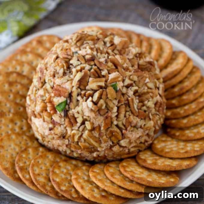 A festive holiday spread featuring the Gouda and Sun-Dried Tomato Cheese Ball, surrounded by various crackers and fresh greens, ready for a party.