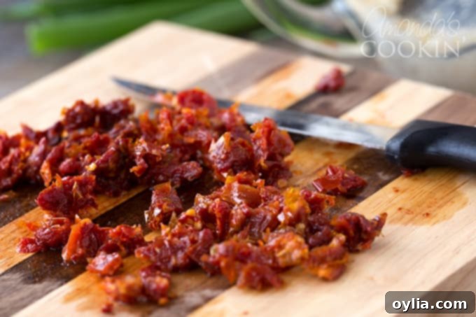 Finely chopped sun-dried tomatoes in a small bowl, ready to be added to the cheese ball mixture.