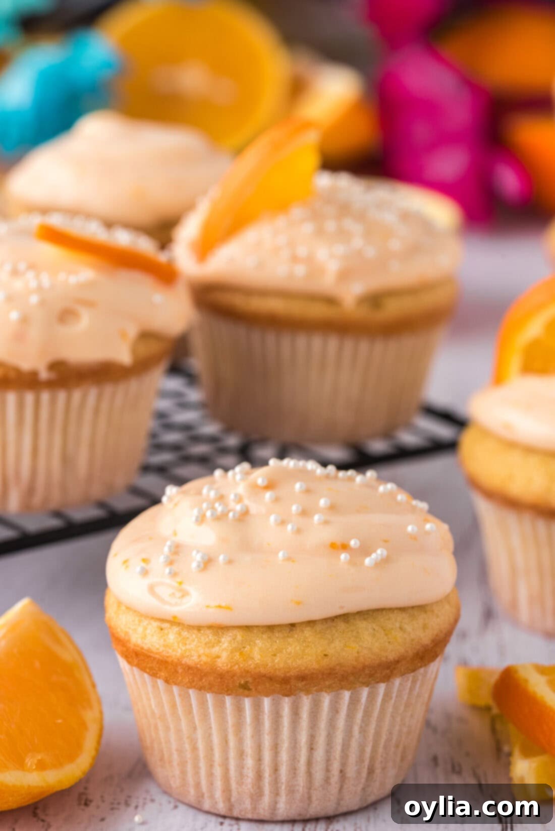 Sunshine Orange Creamsicle Cupcakes 3 Two Orange Creamsicle Cupcakes in the foreground, with more in the background, showcasing their vibrant color and fluffy frosting
