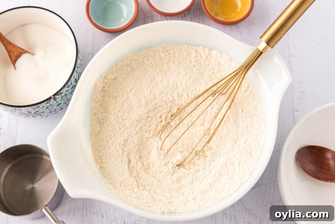Flour, sugar, baking powder, baking soda, and salt whisked in a bowl, showing the uniform mixture of dry ingredients.