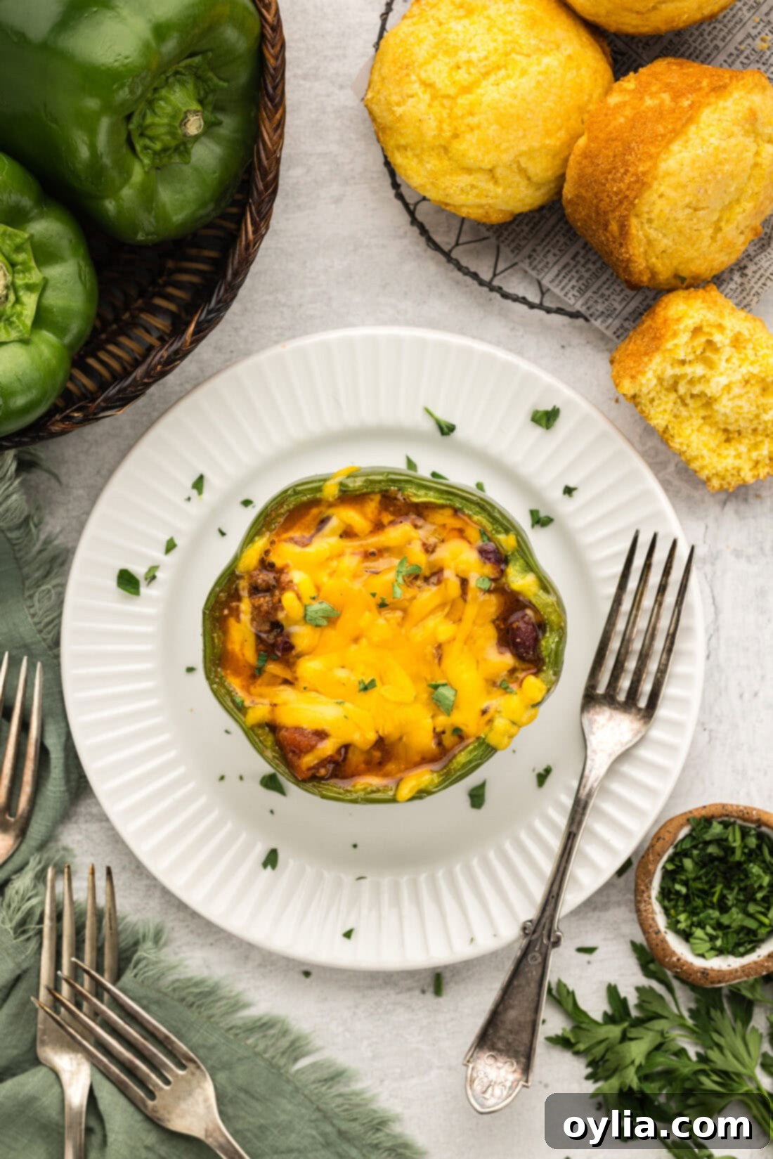 Overhead photo of a Chili and Cornbread Stuffed Pepper on a plate, garnished with fresh herbs