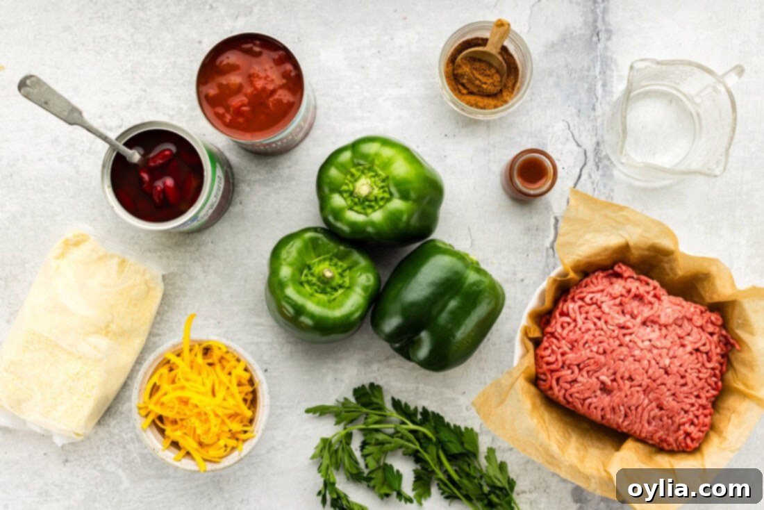 Array of fresh ingredients for Chili and Cornbread Stuffed Peppers laid out on a wooden board