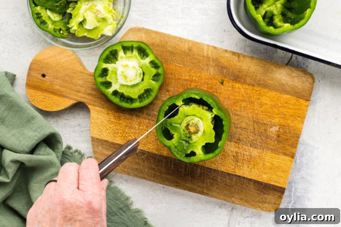 knife cutting membrane out of green bell pepper