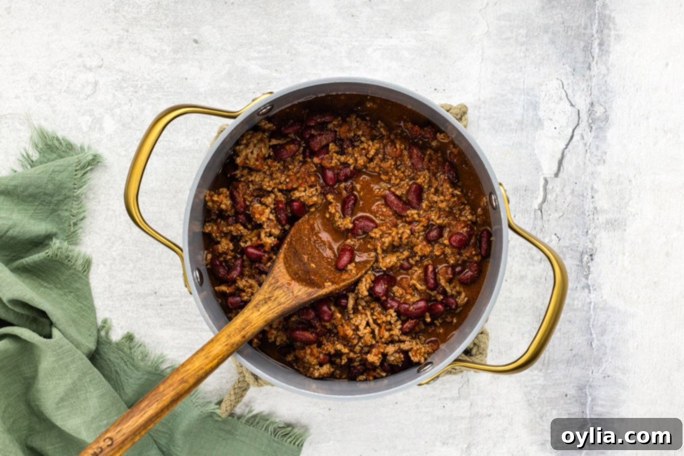 chili in a pot on a wooden spoon