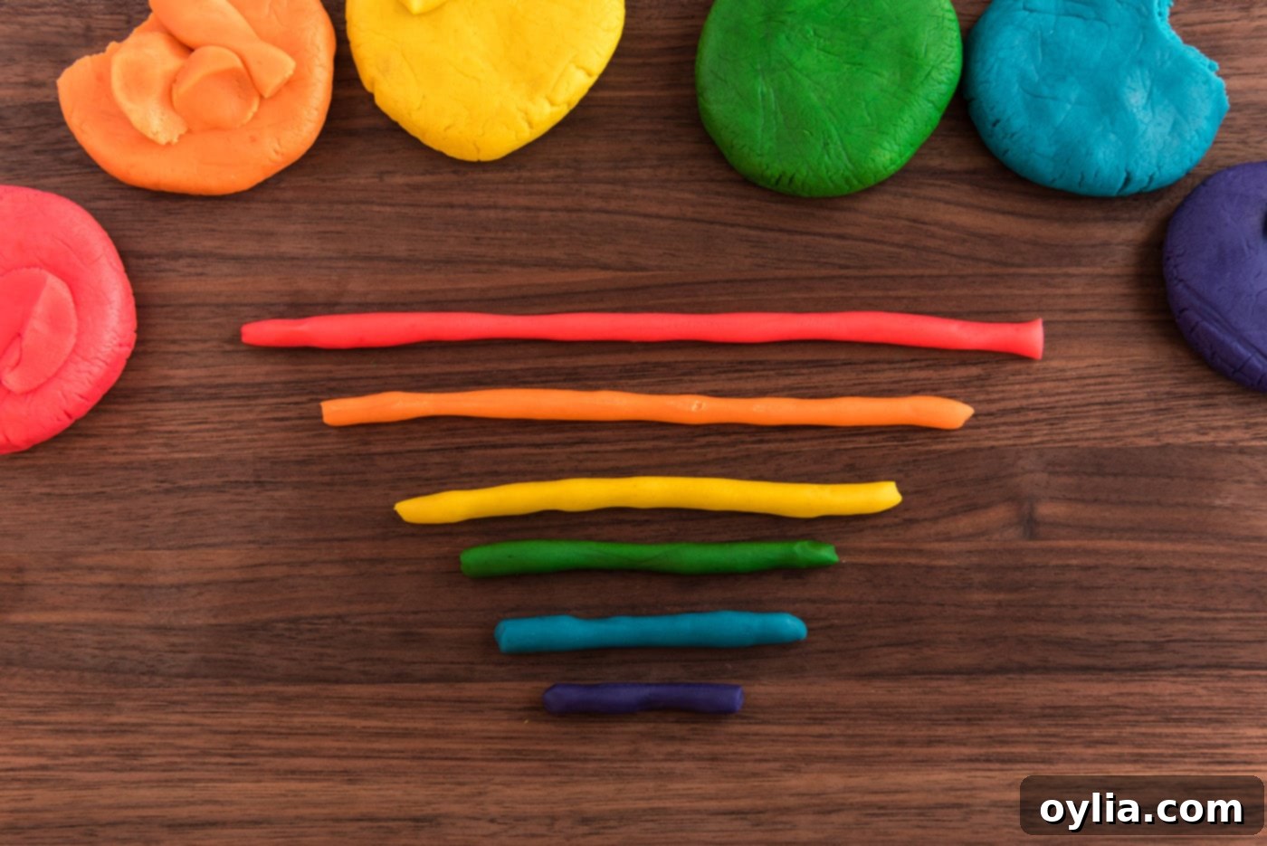 Dough snakes in red, orange, yellow, green, blue, and indigo, ready to be formed into a rainbow.